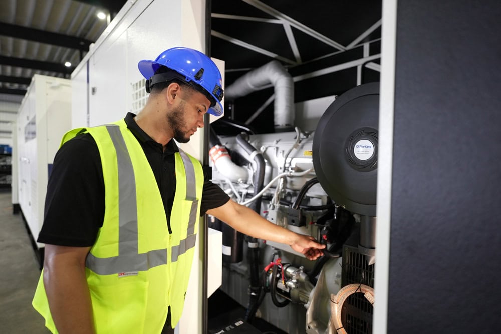 Técnico en uniforme y equipo de seguridad operando maquinaria industrial en un ambiente cerrado
